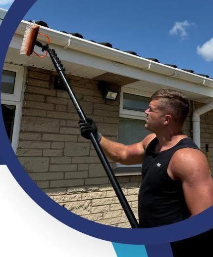 Ash cleaning a gutter with a water-fed pole